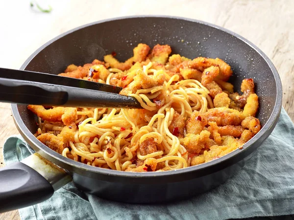 Asian noodles with fried meat on cooking pan — Stock Photo, Image