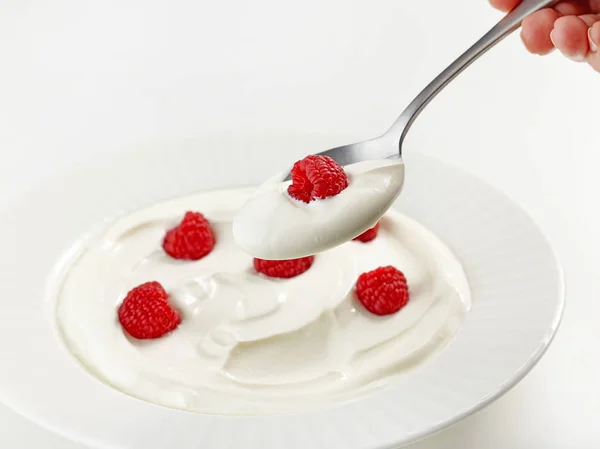 Spoon of greek yogurt with raspberry — Stock Photo, Image
