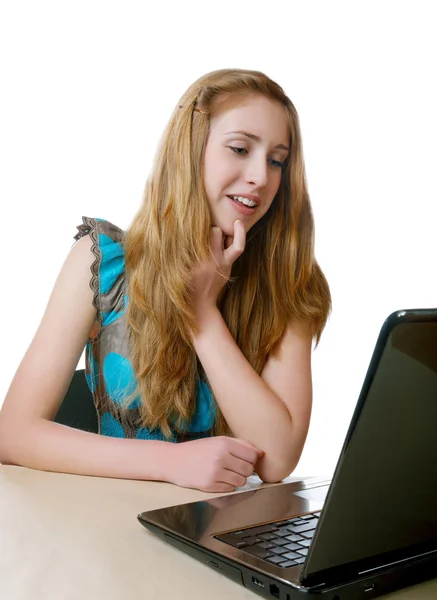 Chica sonriente mira en la pantalla de un ordenador portátil —  Fotos de Stock