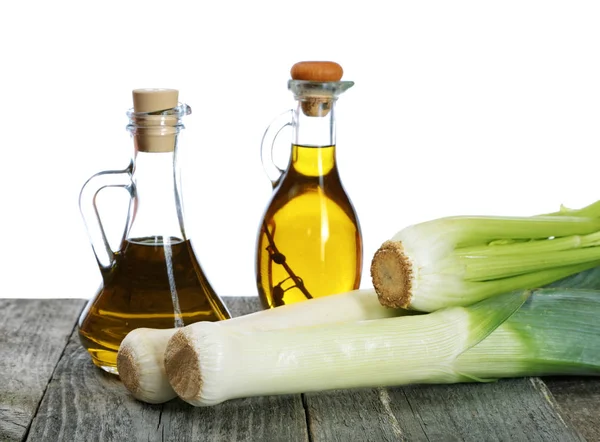 Chalotes y botellas de aceite de oliva sobre mesa rústica — Foto de Stock