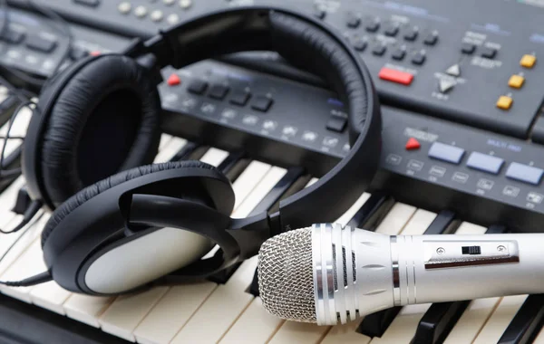 Микрофон и наушники лежат на клавиатуре — стоковое фото