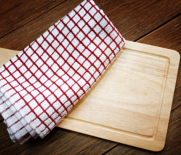 Kitchen towels and cutting board on a table — Stock Photo, Image