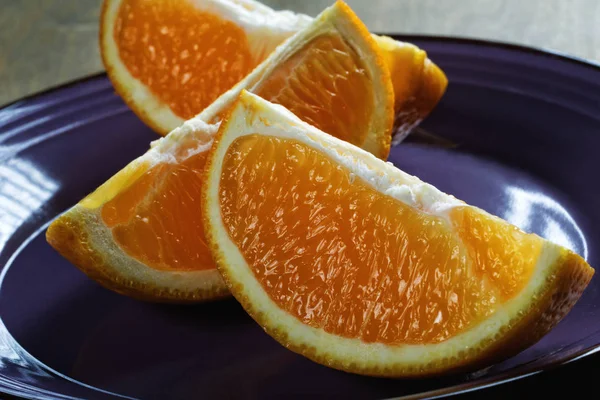Cut plastry pomarańczy na płytce niebieski — Zdjęcie stockowe