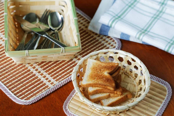 油煎面包块的一个篮子和桌上的餐具 — 图库照片
