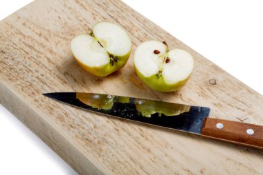 Beyaz zemin üzerinde bir bıçakla kesilmiş elma