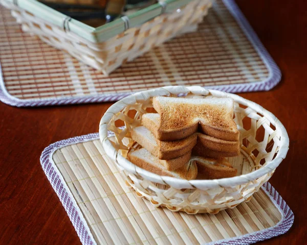 Croutons in a basket and cutlery on a table — Stock Photo, Image