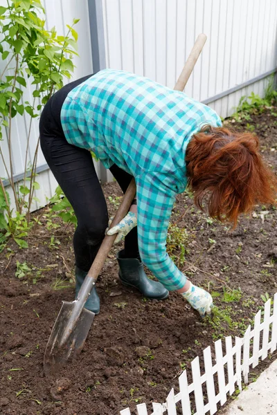 Frau gräbt mit Schaufel in Nahaufnahme eines Gartens — Stockfoto