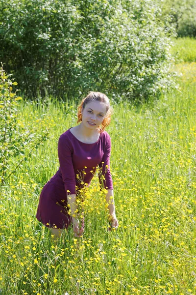 Girl sniffing a meadow flower on a summer day — Stock Photo, Image