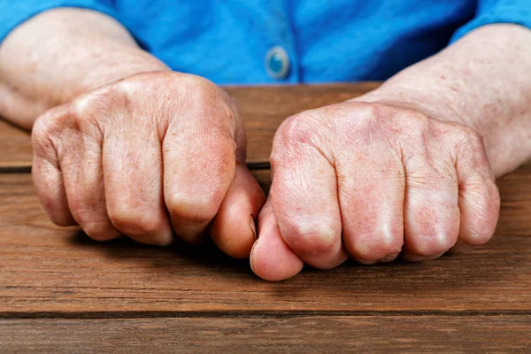 Mãos de uma velha mulher close-up em uma mesa — Fotografia de Stock