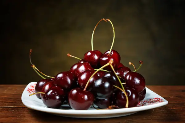 Cherry in a plate on a rural table — Stock Photo, Image