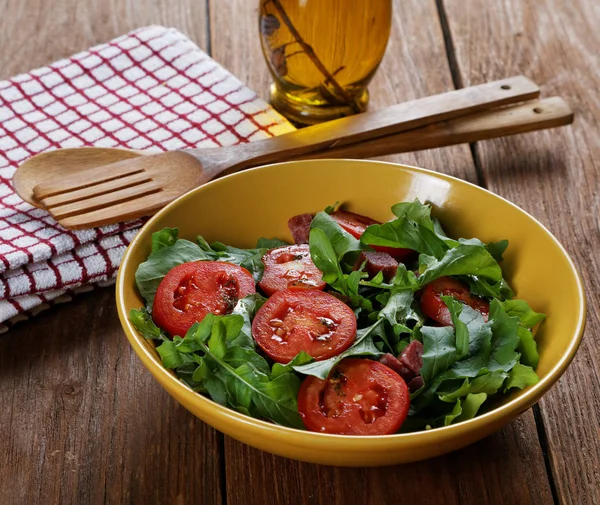 Овочевий салат з помідорами і руколою на столі — стокове фото