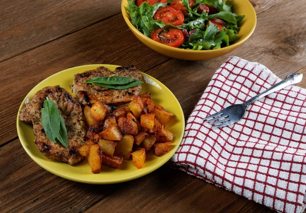 Et ve salata masaya bir tabak kızarmış patates — Stok fotoğraf
