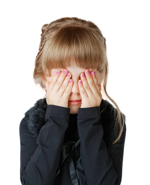 Petite fille couvre son visage avec les mains sur un fond blanc — Photo