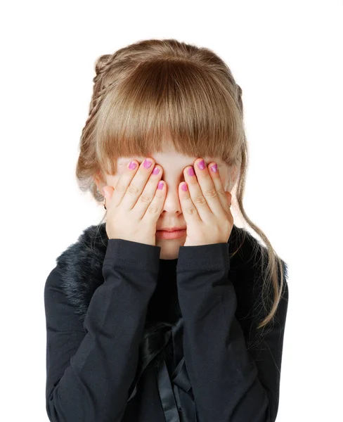 Niña cubre su cara con las manos sobre un fondo blanco —  Fotos de Stock