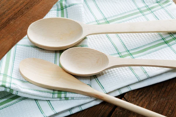 Strofinaccio e cucchiaio di legno sul tavolo — Foto Stock