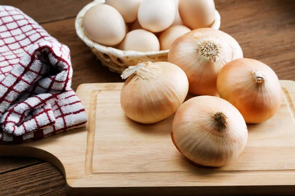 Still life with onions and quail eggs on a kitchen table — Stock Photo, Image