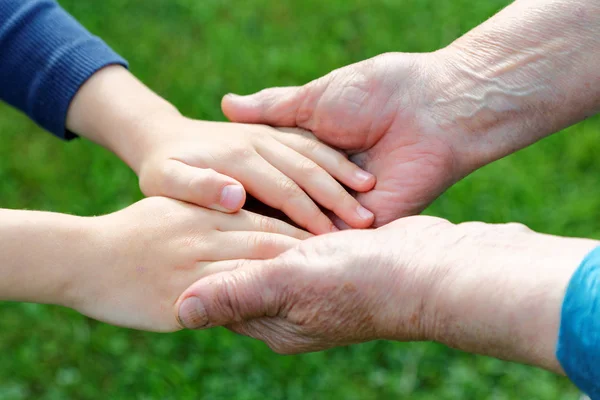 Mano de un niño en la mano de una abuela de cerca — Foto de Stock