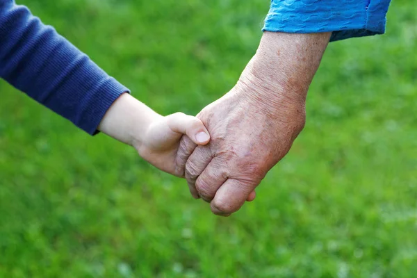 Χέρι του ένα αγόρι στο χέρι του ένα κοντινό πλάνο της γιαγιάς — Φωτογραφία Αρχείου
