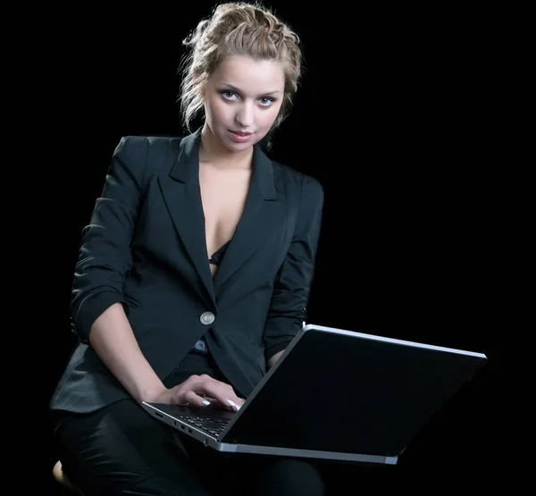 Дівчина в діловому костюмі з ноутбуком на чорному тлі — стокове фото