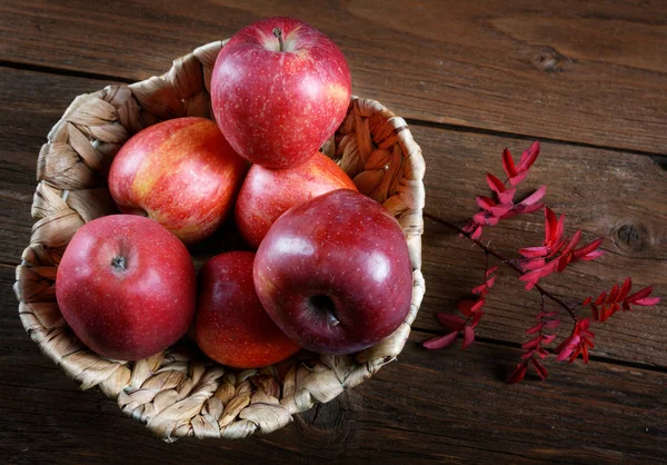Jabłka i suchych gałęzi w wiklinowym koszu — Zdjęcie stockowe