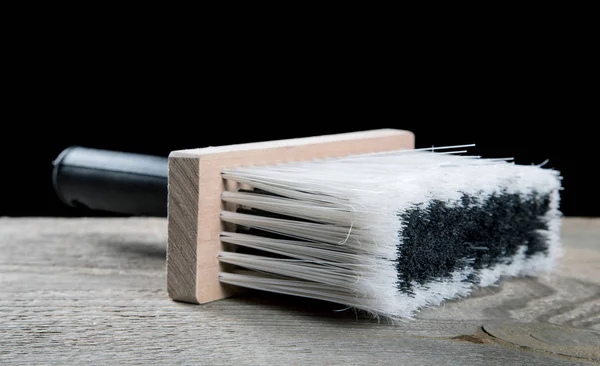 Paint brushes on a wooden table and a black background — Stock Photo, Image