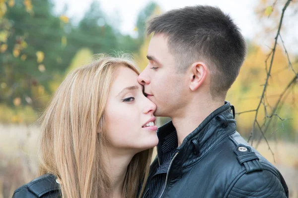 Girl and a young man kissing in the woods — Stock Photo, Image