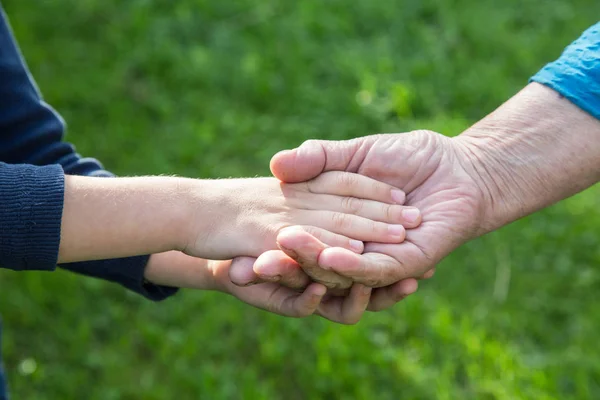 Hand van een jongen in de hand van een close-up van de grootmoeder — Stockfoto