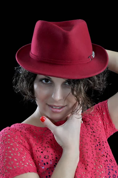Retrato de una chica con un sombrero rojo sobre un fondo negro — Foto de Stock