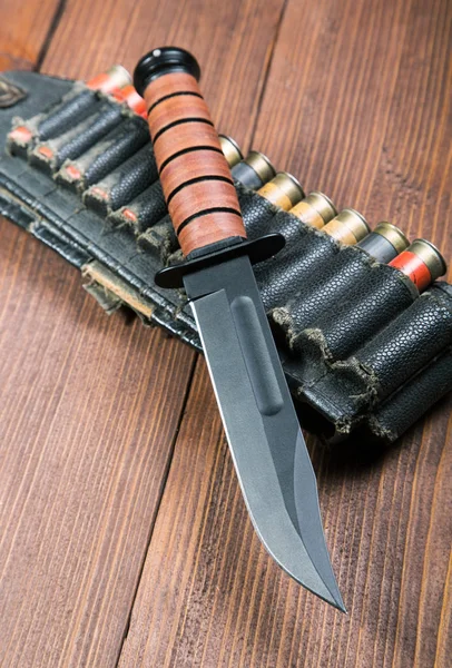 Still life with a knife and bandolier on a close-up table — Stock Photo, Image