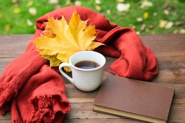 bir eşarp ve bir yığın kitap ile tabloda çay