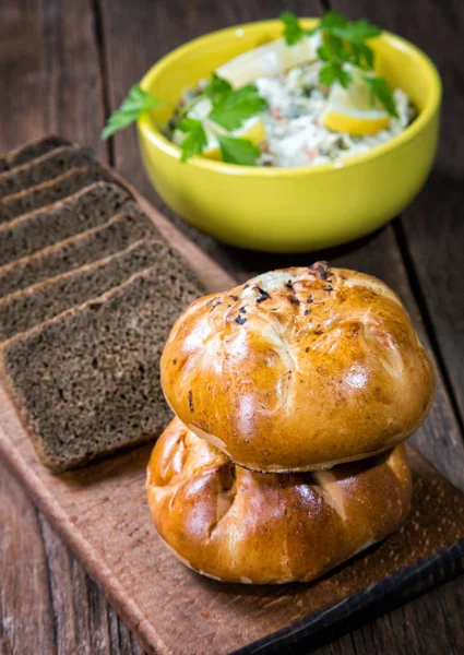 Plate with salad and bread rolls at the village table — Stock Photo, Image