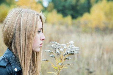 Bir deri ceket sarı çim arasında kız
