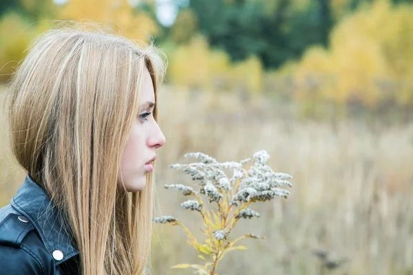 La chica en una chaqueta de cuero entre una hierba amarilla — Foto de Stock