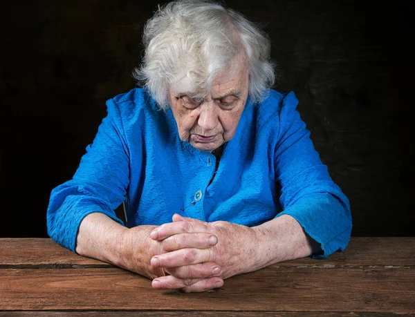 Manos de una anciana de cerca en una mesa — Foto de Stock