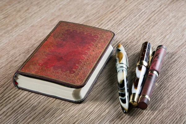 Three fountain pens and diaries with leather cover — Stock Photo, Image