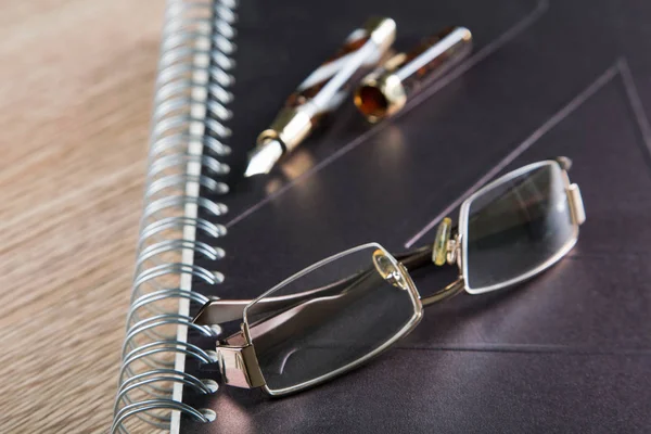 Glasses fountain pens and diaries with leather cover — Stock Photo, Image