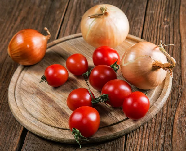 Tomates napiformes de cebolla sobre una vieja mesa rural —  Fotos de Stock