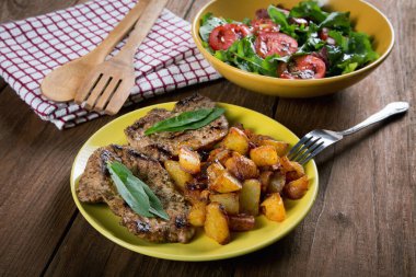 Kırsal bir masada kızarmış patates ve sebze salatası.