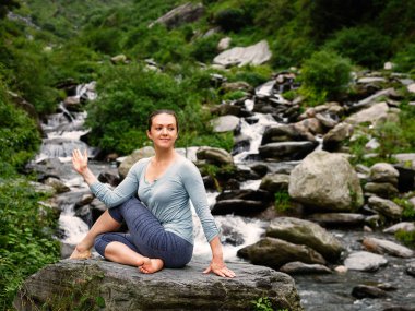 Ardha matsyendrasana asana yapan kadın.