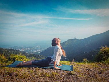 Kadın yoga yapıyor, Urdhva Mukha Svanasana açık havada.