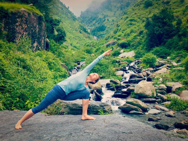 Женщина практикует йогу как Уттхита Парсваконасана на открытом воздухе — стоковое фото