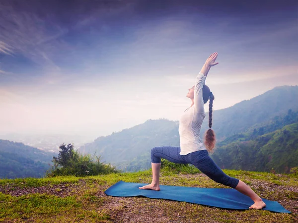 Woman doing yoga asana Virabhadrasana 1 - Warrior pose outdoors — Stock Photo, Image