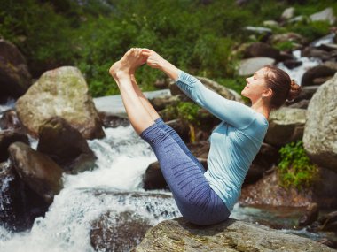 Kadın dışarıda Ashtanga Vinyasa Yoga yapıyor.