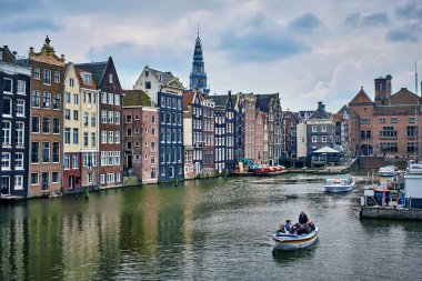 Kanal gezisi turist teknede Amsterdam'da Damrak kanal ve İskelesi