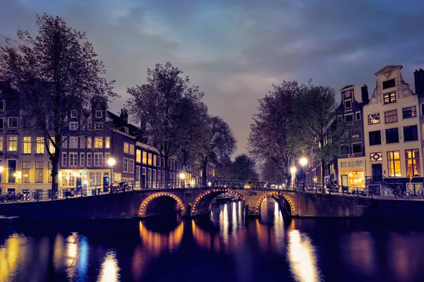 Амтердамский канал, мост и средневековые дома в вечернее время — стоковое фото