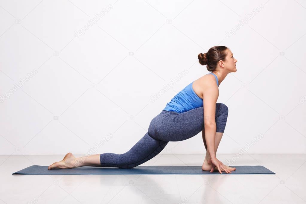 Woman doing Hatha yoga asana Anjaneyasana