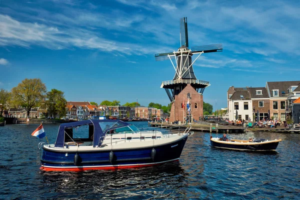 Harlem památka větrný De Adriaan a lodí na řece Spaarne. — Stock fotografie