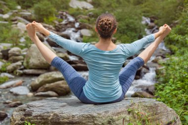 Kadın dışarıda Ashtanga Vinyasa Yoga yapıyor.