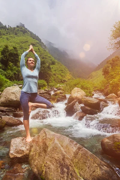 Donna in yoga asana albero Vrikshasana posa a cascata all'aperto — Foto Stock