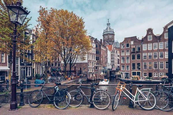 Bicicletas en la calle Amsterdam cerca del canal con casas antiguas —  Fotos de Stock